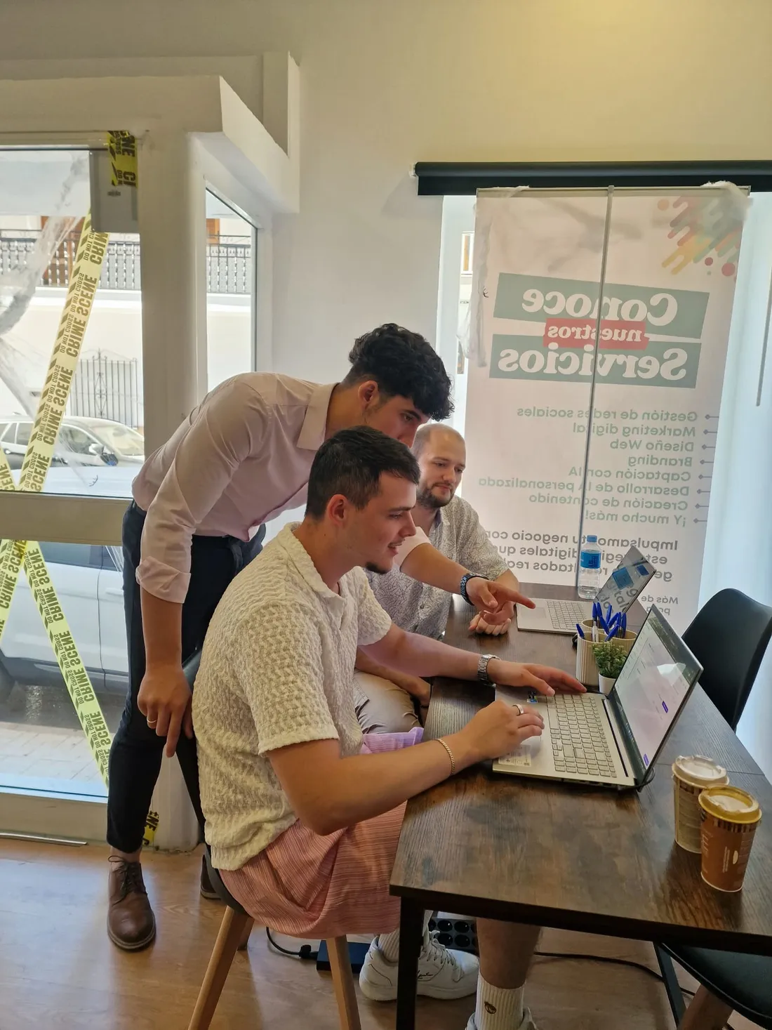 Two team members reviewing a campaign on a laptop while a third points at the screen